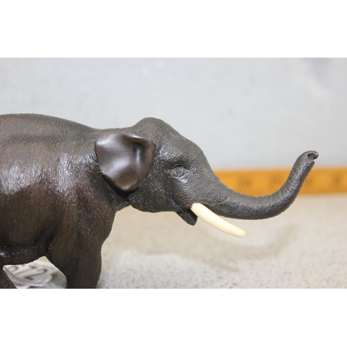 1672 - A cast bronze figure of an elephant, likely 20th century, approx 16cm long, unmarked