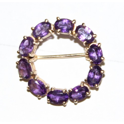 1230 - 9ct gold and amethyst brooch set in a circular pattern, hallmarked for 9ct gold, approx 4.99g gross