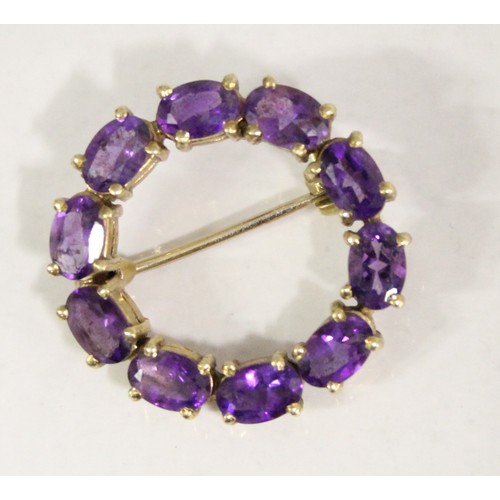 1230 - 9ct gold and amethyst brooch set in a circular pattern, hallmarked for 9ct gold, approx 4.99g gross