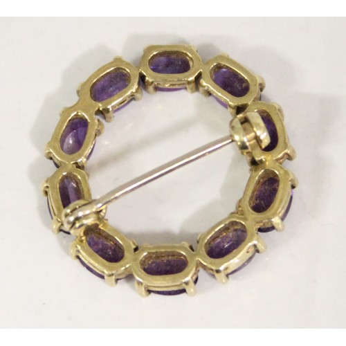 1230 - 9ct gold and amethyst brooch set in a circular pattern, hallmarked for 9ct gold, approx 4.99g gross