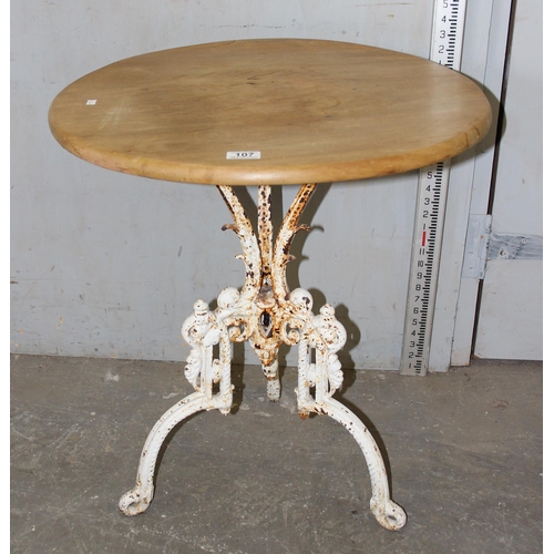 107 - An antique cast iron based table with stripped round wooden top