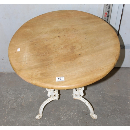 107 - An antique cast iron based table with stripped round wooden top