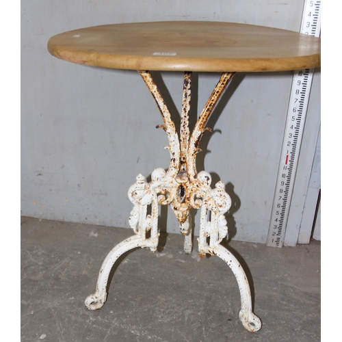 107 - An antique cast iron based table with stripped round wooden top