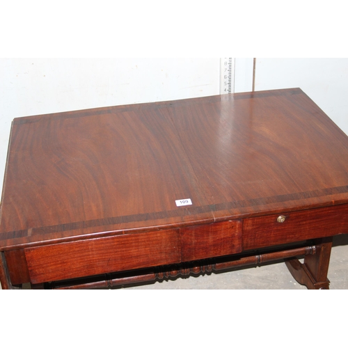 109 - An antique mahogany sofa table with hidden drawers and drop ends with crossbanded decoration