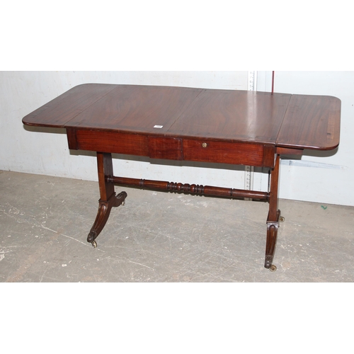 109 - An antique mahogany sofa table with hidden drawers and drop ends with crossbanded decoration