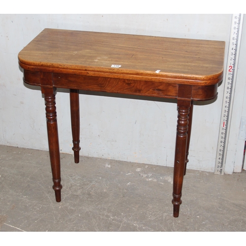 110 - An antique mahogany fold over tea table with turned legs