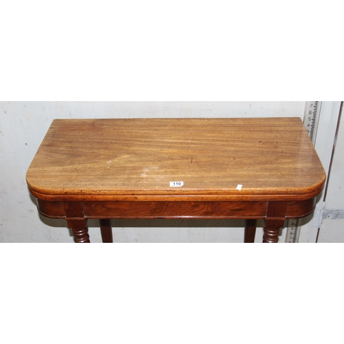 110 - An antique mahogany fold over tea table with turned legs