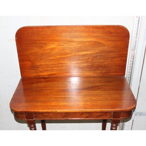 110 - An antique mahogany fold over tea table with turned legs