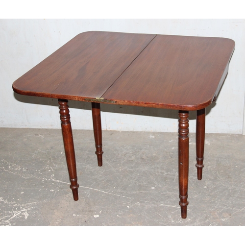 110 - An antique mahogany fold over tea table with turned legs