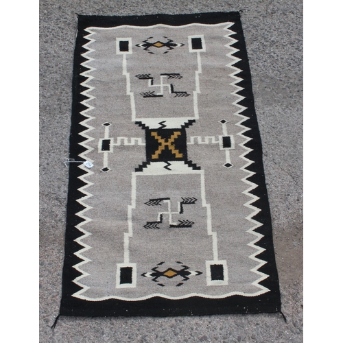 204 - A vintage grey and black ground rug, approx 160 x 80cm