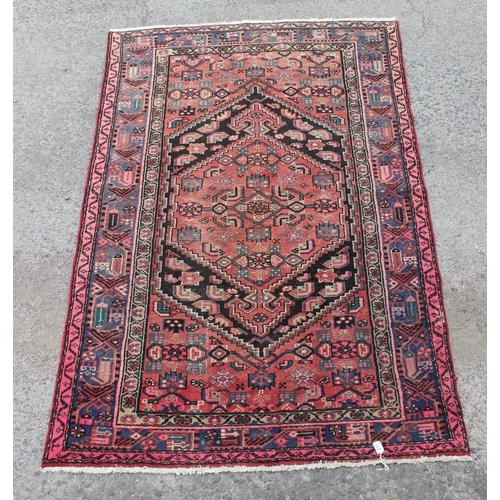 211 - A decorative vintage red ground rug, handmade, approx 205cm x 135cm