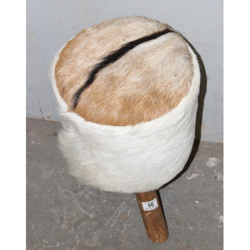 96 - An unusual animal hide upholstered stool on tripod wooden legs