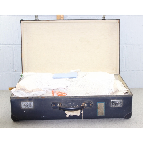 220 - A vintage blue suitcase containing linen and lace, other fabrics etc