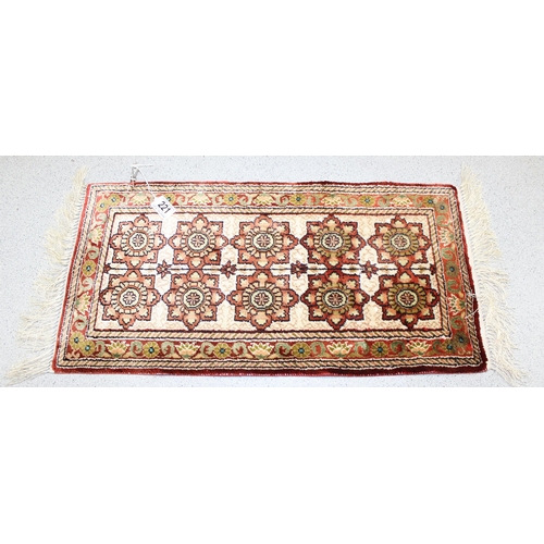 221 - A small finely woven rug of red and cream ground, believed to be silk, knot count approximately 360 ... 