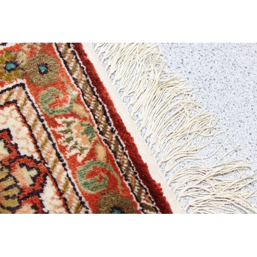 221 - A small finely woven rug of red and cream ground, believed to be silk, knot count approximately 360 ... 