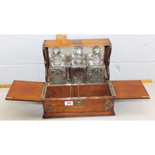 285 - An antique oak cased 3 bottle tantalus and games box