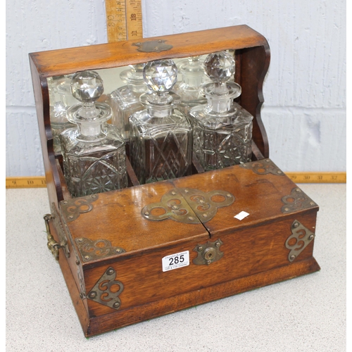 285 - An antique oak cased 3 bottle tantalus and games box