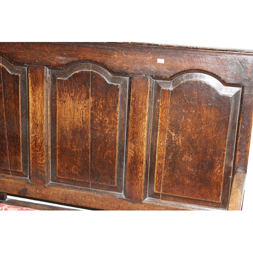 6 - An 18th century oak hall bench, the low rectangular back with 5 panels and scroll arms above a long ... 