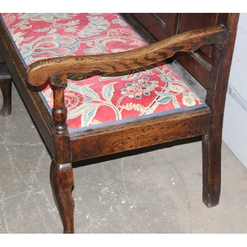 6 - An 18th century oak hall bench, the low rectangular back with 5 panels and scroll arms above a long ... 