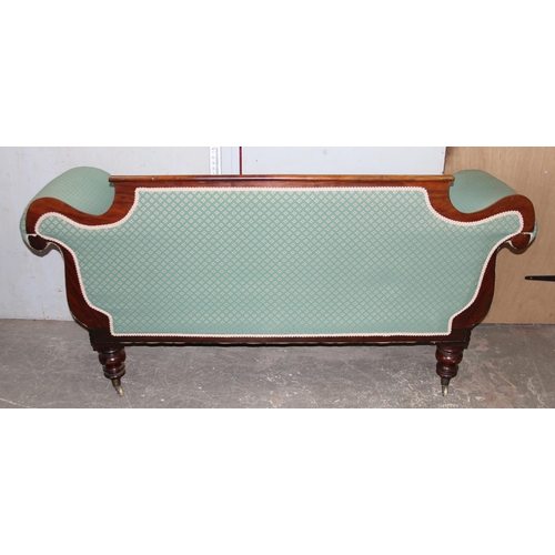 142 - A 19th century mahogany scroll arm sofa with brass cup castors, later green upholstery with matching... 