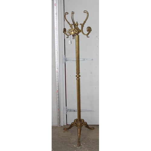 151 - A vintage brass coat stand decorated with female masks to the base