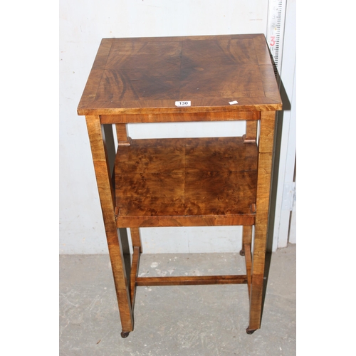 130 - A 1930’s Art Deco walnut veneered two tier stand on metal castors.