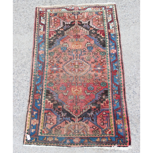 223 - A large antique handmade rug of red ground, approx 155cm x 95cm