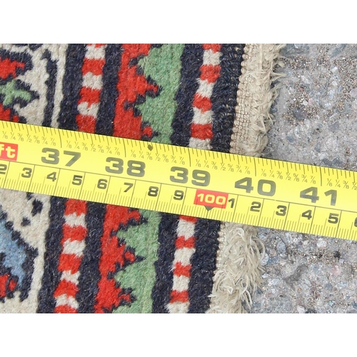 227 - A decorative vintage hand made rug of red and blue ground, approx 100cm long