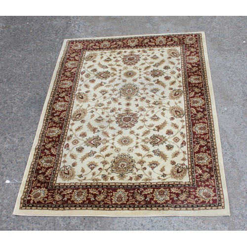 229B - A large modern cream ground rug decorated with arabesque motifs, approx 225cm x 163cm