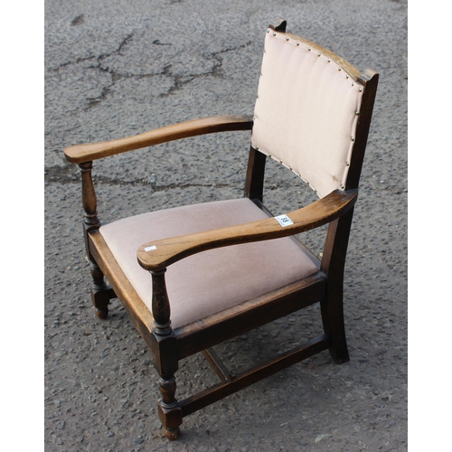 184 - A vintage low oak armchair with matching stool with carved details (2)