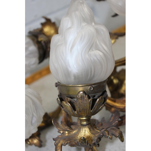 265 - A vintage gilt bronze hanging light fitting with 5 frosted glass flame designed shades