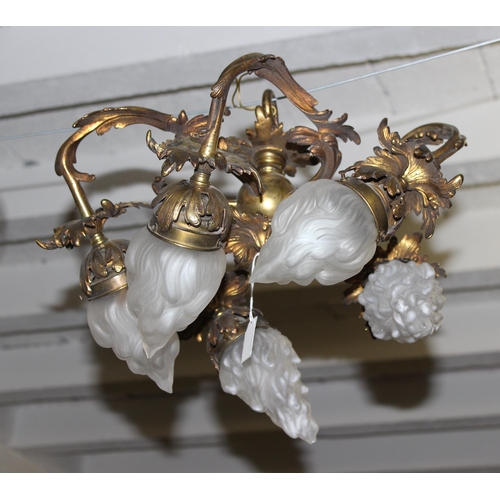 265 - A vintage gilt bronze hanging light fitting with 5 frosted glass flame designed shades