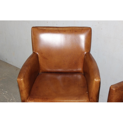 88 - A pair of tan leather carver armchairs with wooden legs, likely John Lewis