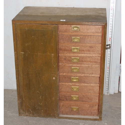 28 - A vintage wooden cupboard containing 9 drawers with campaign style brass handles, approx 76cm wide