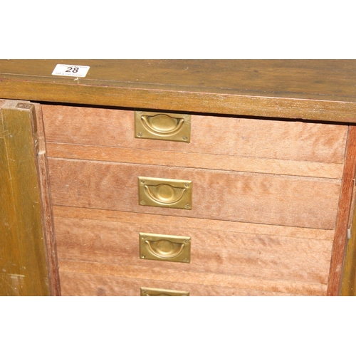 28 - A vintage wooden cupboard containing 9 drawers with campaign style brass handles, approx 76cm wide