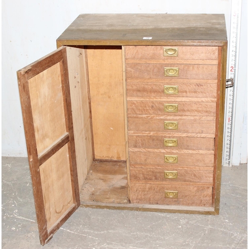 28 - A vintage wooden cupboard containing 9 drawers with campaign style brass handles, approx 76cm wide