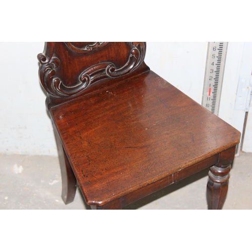 14 - A 19th century mahogany hall chair with carved back