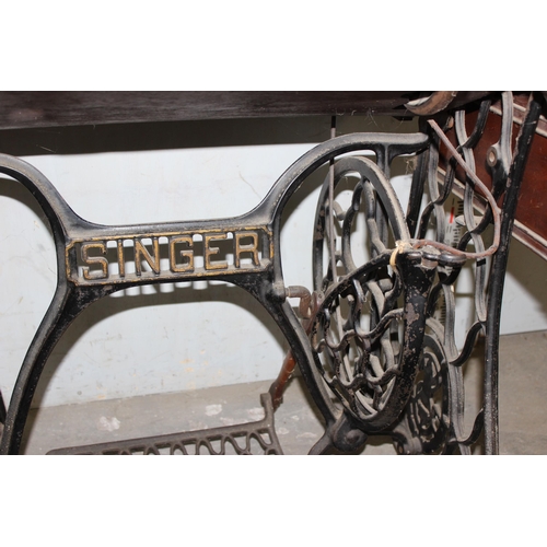 53 - Vintage Singer sewing machine with cast iron peddle base and walnut worktop.