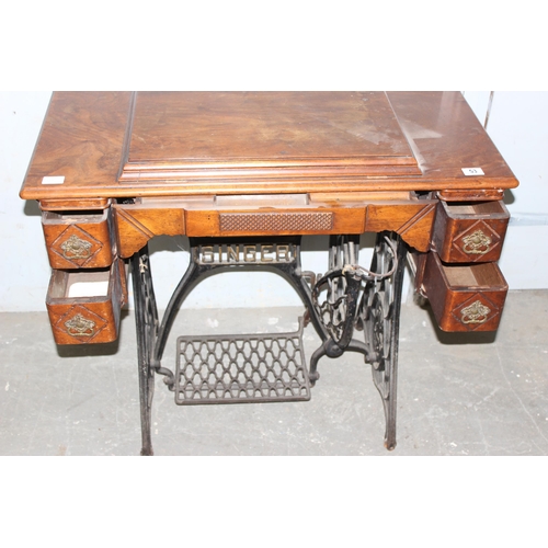 53 - Vintage Singer sewing machine with cast iron peddle base and walnut worktop.