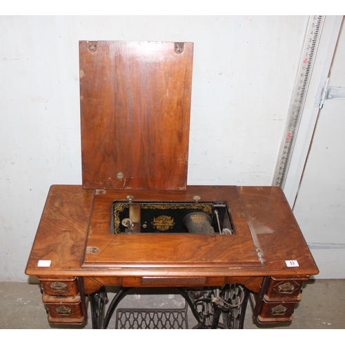 53 - Vintage Singer sewing machine with cast iron peddle base and walnut worktop.