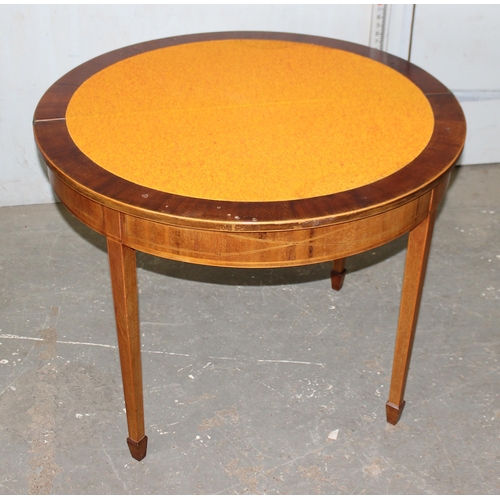 7 - A Georgian style demi-lune card table with cross banded decoration standing on spade legs