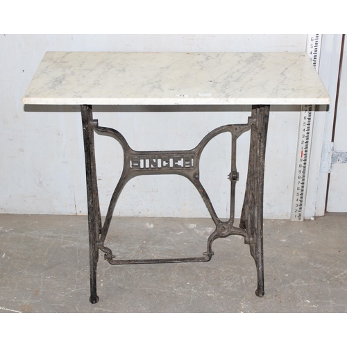 73 - A vintage cast iron Singer Sewing machines table base with marble top, approx 92cm wide