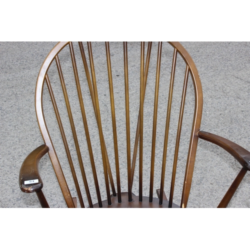 94 - An Ercol dark finished hoop back rocking chair with blue & gold label