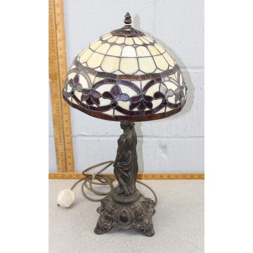 260 - A Tiffany style table lamp with leaded glass shade and a bronzed metal base formed as a classical fe... 