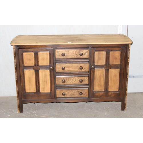 105 - An Ercol 4 drawer 2 door sideboard with stripped top