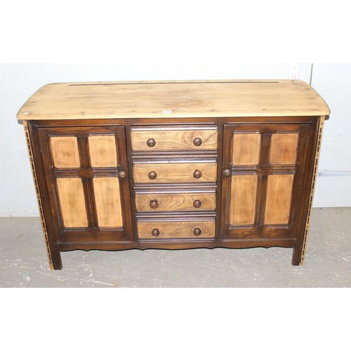 105 - An Ercol 4 drawer 2 door sideboard with stripped top