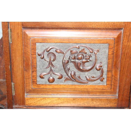 120 - An antique mahogany wall cabinet with well carved panel decoration