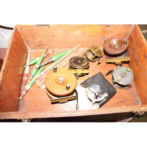 709 - A interesting box of antique and later fishing tackle to include line winders , wooden fishing float... 