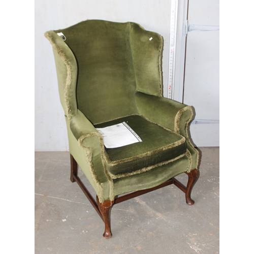 13 - A vintage green upholstered wingback armchair, Georgian style