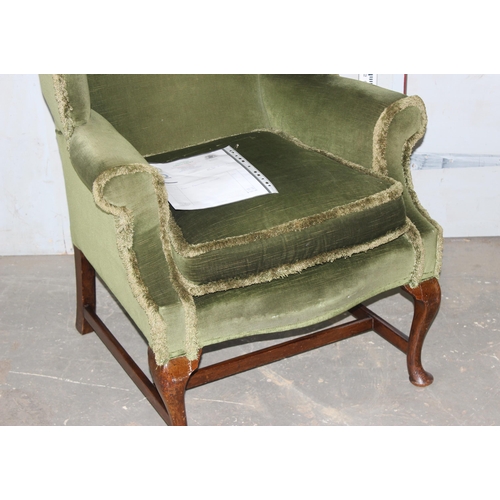 13 - A vintage green upholstered wingback armchair, Georgian style